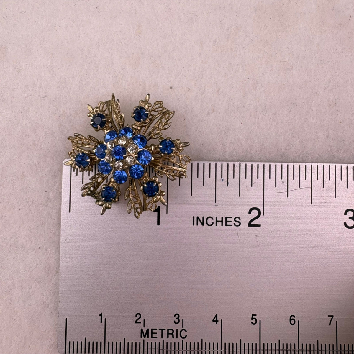 Vintage Unknown Blue Gold Tone Rhinestone Snowflake Brooch Resin Round Pin