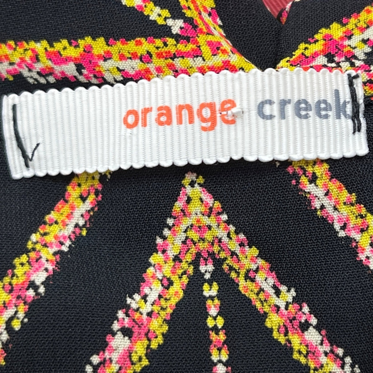 Orange Creek Women's Black Sleeveless Romper With Orange Geometric Print